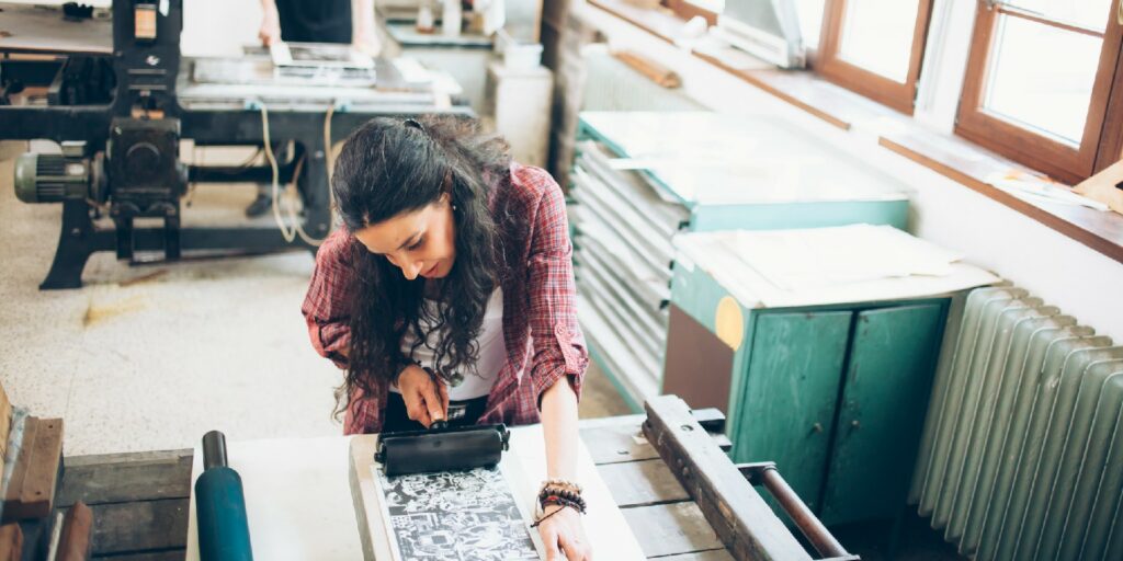 Man and woman lithography workers handmaking new products at their workshop