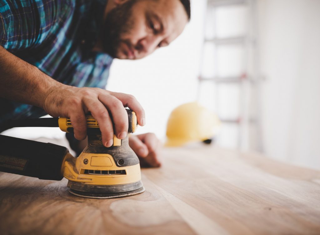 Man using a sander on wood