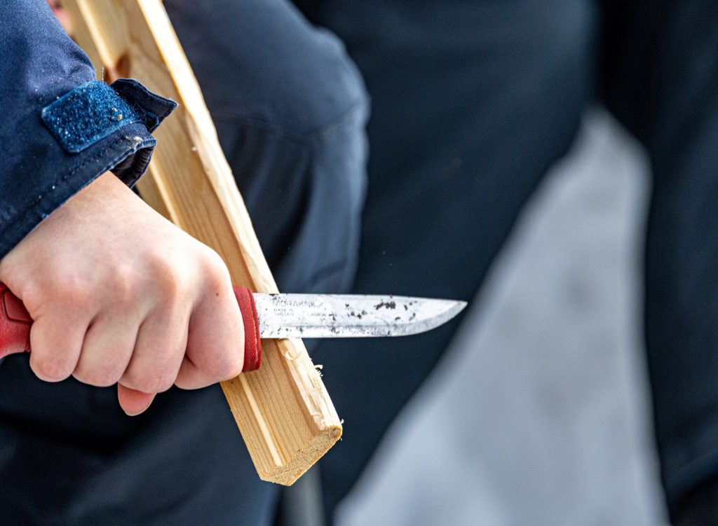 Man carving wood with a knife