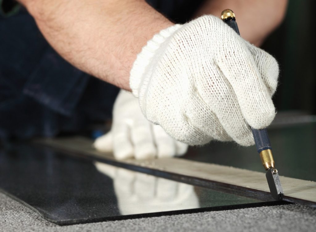 Person marking a glass surface for cutting